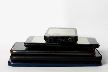 Photo for Old mobile phones piled up on a table - Royalty Free Image