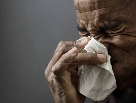 Foto de Soplado nariz después de coger el resfriado y la gripe con fondo gris con la gente stock imagen foto - Imagen libre de derechos