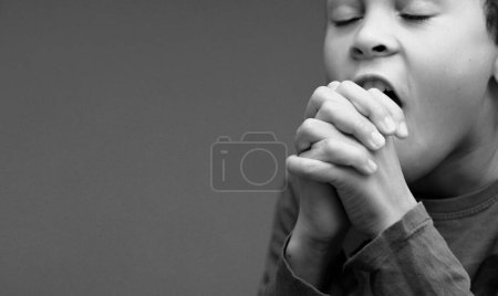 Photo for Boy praying to God all by himself with people stock image stock photo - Royalty Free Image