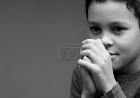 Téléchargez les photos : Garçon priant Dieu tout seul avec les gens image de stock photo de la réserve - en image libre de droit