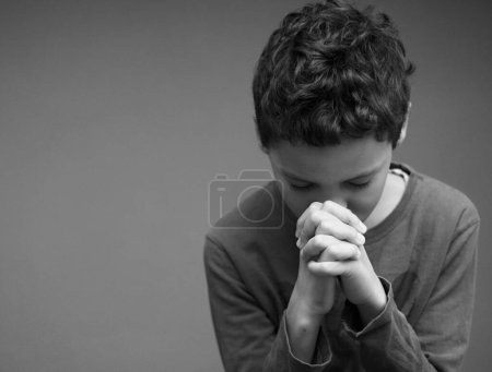 Photo for Boy praying to God all by himself with people stock image stock photo - Royalty Free Image