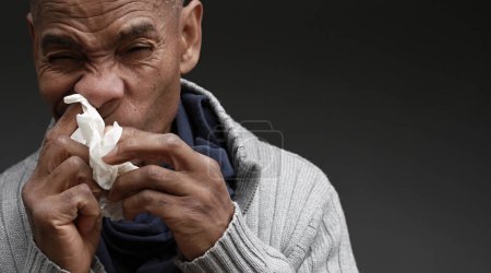 Foto de Resfriado y la gripe que sopla la nariz después de contraer la gripe con fondo negro gris con la gente imagen stock foto - Imagen libre de derechos