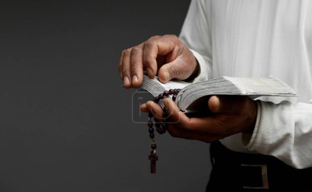 Foto de Hombre orando a Dios sosteniendo el libro bíblico - Imagen libre de derechos