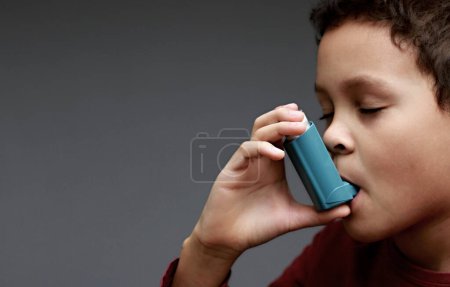 Photo for Child with flu and inhaler respiratory puff on grey background with people stock image stock photo - Royalty Free Image