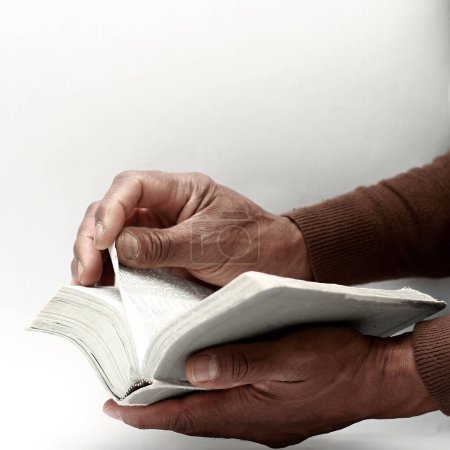 Foto de Hombre orando a Dios sosteniendo el libro bíblico - Imagen libre de derechos