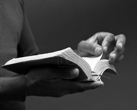 Foto de Orando a Dios sosteniendo el libro bíblico - Imagen libre de derechos