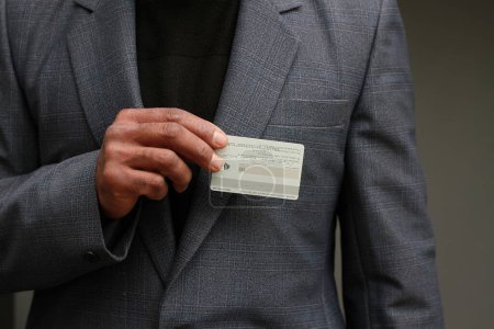 Téléchargez les photos : Homme d'affaires avec carte blanche vierge sur fond gris - en image libre de droit