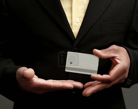 Foto de Hombre de negocios con tarjeta blanca en blanco sobre fondo gris - Imagen libre de derechos