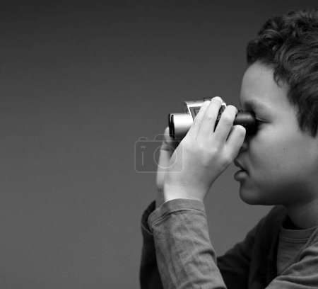 Photo for Young boy looking through binoculars - Royalty Free Image