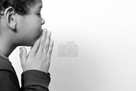 Téléchargez les photos : Petit garçon priant Dieu sur fond de studio - en image libre de droit