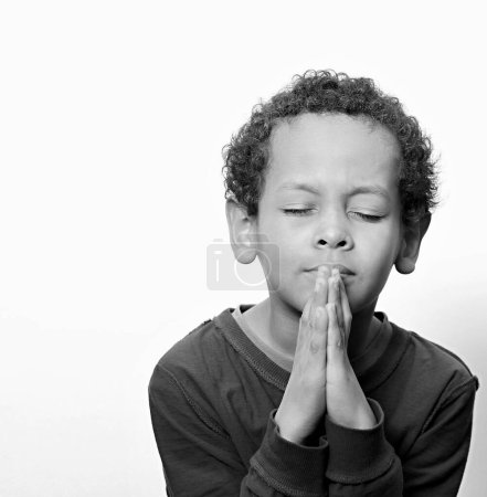 Foto de Niño rezando a Dios contra el fondo del estudio - Imagen libre de derechos