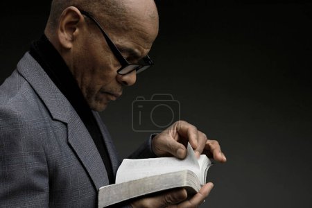 Photo for Caribbean man with bible book praying to god - Royalty Free Image