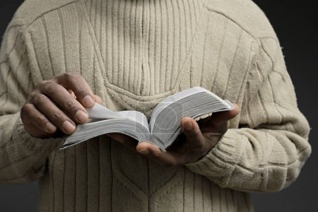Foto de Hombre caribeño con libro bíblico rezando a Dios - Imagen libre de derechos