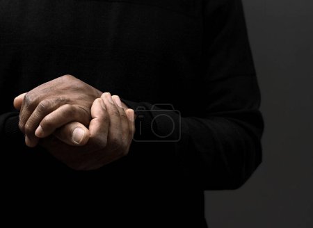 Photo for Hands of person praying on dark background, close - up view - Royalty Free Image
