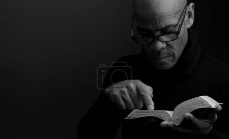 Photo for Man holding the holy bible book prying - Royalty Free Image