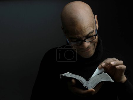 Foto de Hombre sosteniendo el libro sagrado de la Biblia entrometiéndose - Imagen libre de derechos