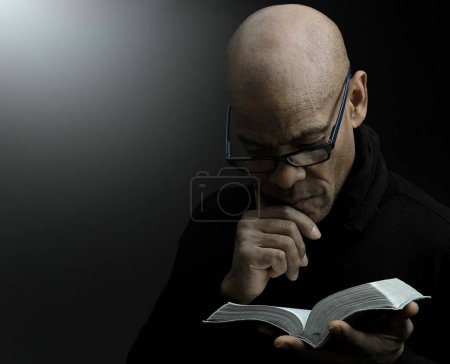 Téléchargez les photos : Homme tenant le livre de la bible sainte indiscret - en image libre de droit