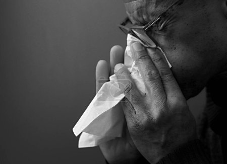 Téléchargez les photos : Nez soufflant après avoir attrapé un rhume avec fond gris - en image libre de droit