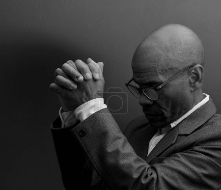 Photo for Black man praying to god with black grey background - Royalty Free Image