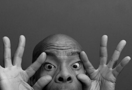 Téléchargez les photos : Homme frottant ses yeux avec fond noir gris - en image libre de droit