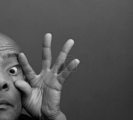 Foto de Hombre frotando sus ojos con fondo gris negro - Imagen libre de derechos