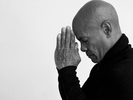 Téléchargez les photos : Homme noir priant Dieu avec fond gris noir - en image libre de droit