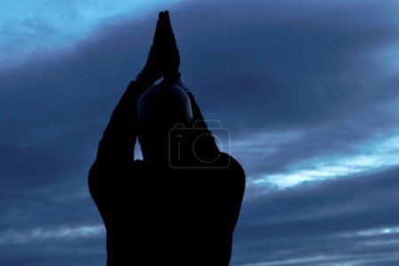 Téléchargez les photos : Silhouette d'un homme au ciel nuageux en soirée sur fond - en image libre de droit