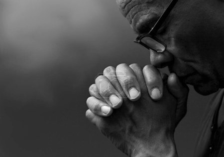 Foto de Negro caribeño hombre orando a dios en negro fondo - Imagen libre de derechos