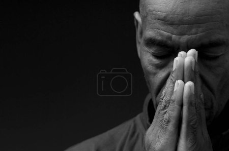 Photo for Black Caribbean man praying to god on black background - Royalty Free Image