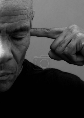 man suffering from deafness and hearing loss on grey background