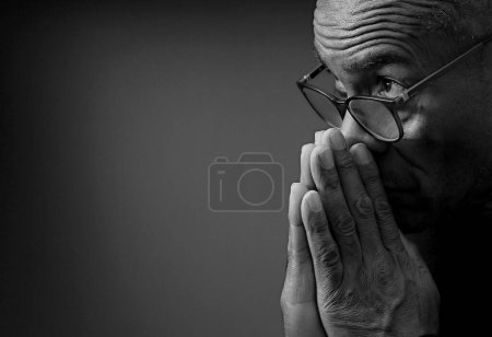 Téléchargez les photos : Homme caribéen priant Dieu avec les mains ensemble, photo studio noir et blanc - en image libre de droit