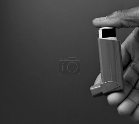 Male hand with asthma spray inhaler for people with breathing problems 