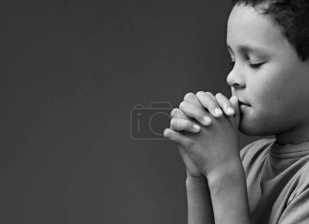 Téléchargez les photos : Enfant garçon priant Dieu avec les mains ensemble sur fond blanc - en image libre de droit