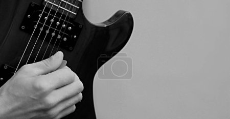 Foto de Hombre tocando la guitarra eléctrica con fondo gris - Imagen libre de derechos