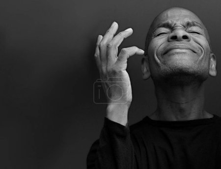 Photo for Caribbean man praying to god, black and white studio portrait - Royalty Free Image