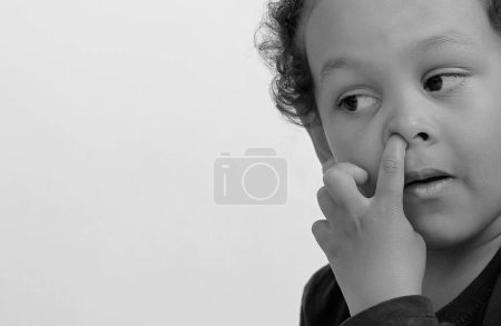 Photo for Child boy picking nose with white background, studio shot - Royalty Free Image