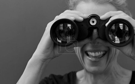 Foto de Mujer mirando a través de prismáticos, retrato de estudio - Imagen libre de derechos
