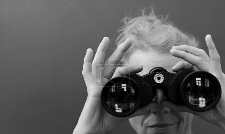 Photo for Woman looking through binoculars, studio portrait - Royalty Free Image