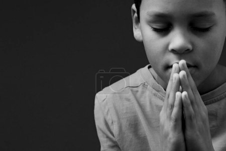 Téléchargez les photos : Enfant garçon priant Dieu, image noir et blanc - en image libre de droit