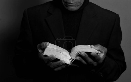 Foto de Hombre rezando a Dios con la Biblia en las manos - Imagen libre de derechos