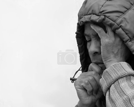 Foto de Hombre en la capucha rezando a Dios con las manos sobre fondo blanco, blanco y negro - Imagen libre de derechos