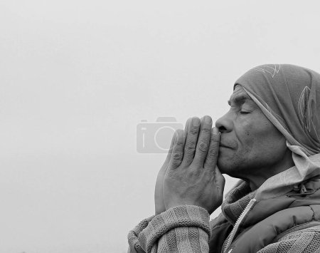 Téléchargez les photos : Homme priant Dieu avec les mains sur fond blanc, noir et blanc - en image libre de droit