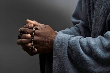 Foto de Hombre rezando a Dios con las manos con la cruz, primer plano - Imagen libre de derechos