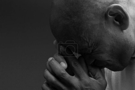 Foto de Hombre rezando a Dios con las manos en el fondo negro - Imagen libre de derechos