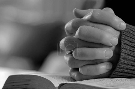 Téléchargez les photos : Vue rapprochée de la personne priant Dieu avec les mains sur la bible - en image libre de droit
