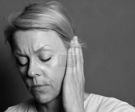 Téléchargez les photos : Woman with deafness and hearing loss on grey background - en image libre de droit