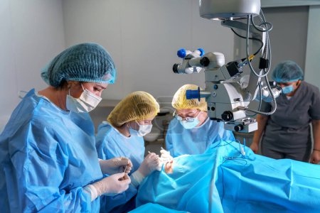 Photo for Blepharoplasty plastic surgery. Rejuvenation and modification of the area around the eyes. Plastic surgeon and nurses doing eyelid surgery on a female patient using a microscope - Royalty Free Image