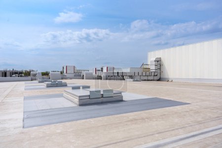 The air conditioning and ventilation system of a large industrial building is located on the roof. It consists of air ducts, air conditioning, smoke removal and ventilation