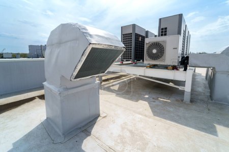 Téléchargez les photos : Le système de climatisation et de ventilation d'un grand bâtiment industriel est situé sur le toit. Grands tuyaux métalliques pour conduits d'air, climatisation, évacuation de la fumée et ventilation - en image libre de droit