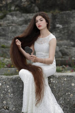 Inszenierung des Gemäldes Lady Lilith von Dante Gabriel Rossetti, junge Frau in weißem Kleid, die Haare kämmt und in den Spiegel blickt